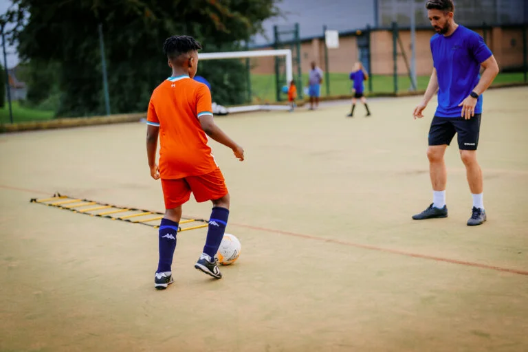 A Foot-Tech coach working one-to-one with a young player